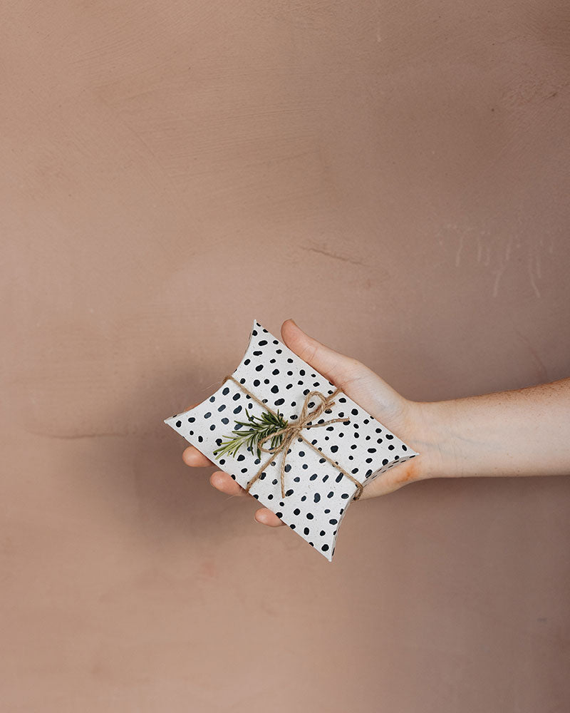 Nachhaltige Pillowbox aus Graspapier mit schwarz weißem Punktemuster. Verpacke dein Geschenk in unserer schönen Geschenkschachtel. Die Box wird in Deutschland hergestellt und bedruckt.